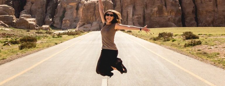 Woman jumping in midle of road