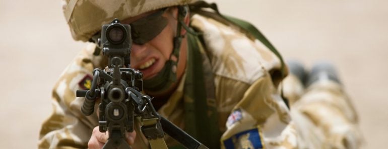 A British soldier aims a LMG