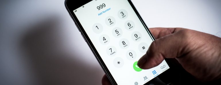 London, LondonUK - April 02 2019 iPhone being used to dial emergency phone numbers, 999, 911, 112 white background with mans hand holding mobile or cell phone - Image( Simon Vayro)S