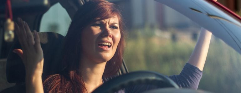 Closeup portrait, angry young sitting woman pissed off by drivers in front of her and gesturing with hands. Road rage traffic jam concept - Image(perfectlab)s