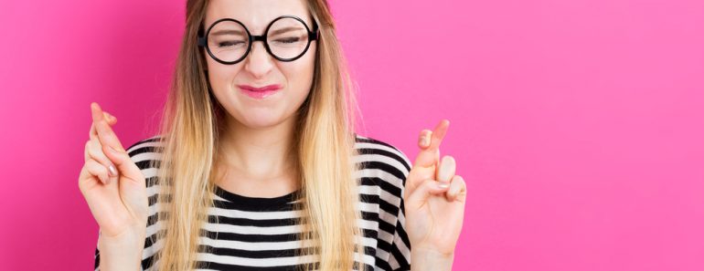 Young woman crossing her fingers and wishing for good luck(TierneyMJ)s