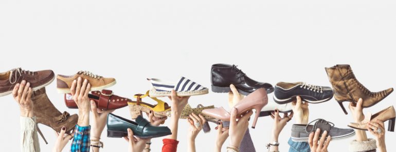 Hands holding different shoes on isolated background(sebra)s