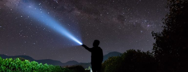 An amazing milky way and stargazing with a silhouette man flashing the light towards the stars(yusuf madi)S