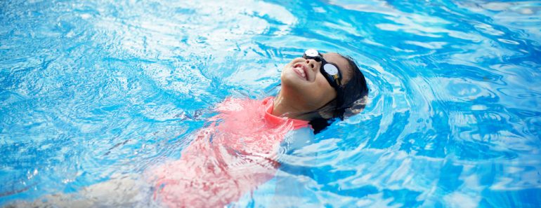 Young,Asian,Child,With,Peach,Swimwear,Floating,In,Pool.swimming,Lesson.